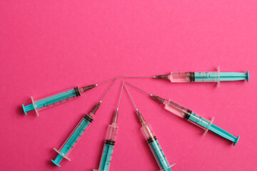 Medical syringe on a pink background. A syringe for injection. The concept of health and beauty