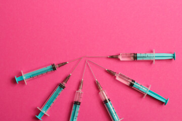 Medical syringe on a pink background. A syringe for injection. The concept of health and beauty