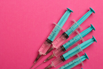 Medical syringe on a pink background. A syringe for injection. The concept of health and beauty