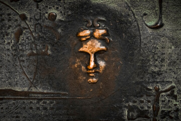 close-up of a bronze sculpture depicting the face of a woman on the entrance door to the Sagrada...