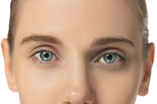 Cropped close-up image of beautiful blue female eyes looking at camera. Natural cosmetics