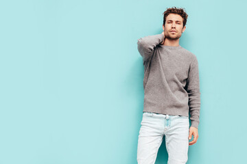 Portrait of handsome confident  model. Sexy stylish man dressed in  sweater and jeans. Fashion...