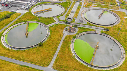 Aerial view of the tanks of a sewage and water treatment plant enabling the discharge and re-use of waste water. It's a sustainable water recycling with treatment plant.