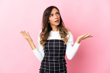 Young caucasian woman isolated on pink background stressed overwhelmed