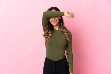 Young caucasian woman isolated on pink background covering eyes by hands