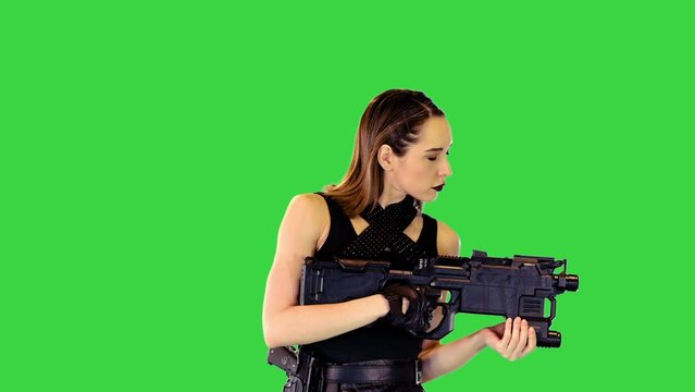 Girl in black tank top and leather skirt poses with a gun in hands, making yeah on a Green Screen, Chroma Key.