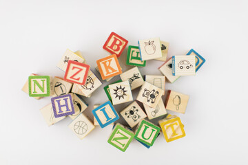 A pile of children painted alphabet wooden blocks isolated with white background for text copy space. 