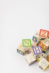 A pile of children painted alphabet wooden blocks isolated with white background for text copy...