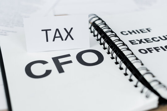 close up of paper with tax lettering near notebook with cfo word.