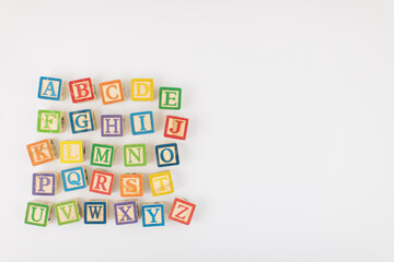 An arrangement of children painted alphabet wooden blocks isolated with white background for text copy space.  - Powered by Adobe