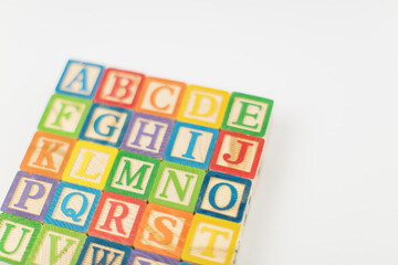 An arrangement of children painted alphabet wooden blocks isolated with white background for text copy space. 