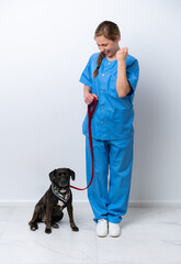 Full body veterinarian woman with a dog isolated on white background celebrating a victory