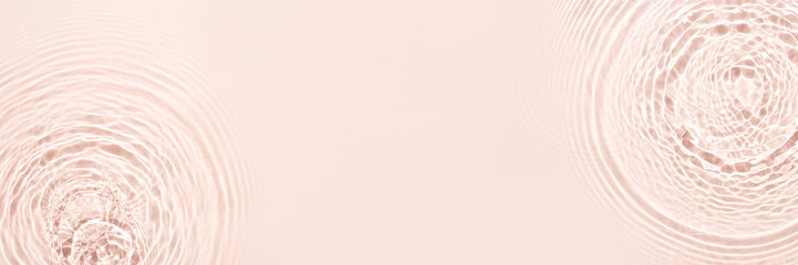 The texture of water on a pink background in bright sunlight.