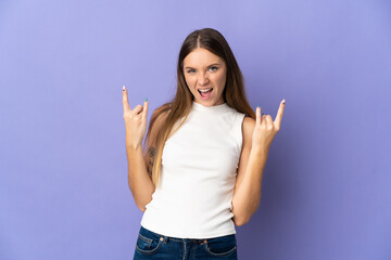 Young Lithuanian woman isolated on purple background making horn gesture