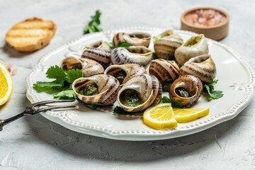 Escargots de Bourgogne Snails with herbs, butter, garlic, glass of white wine on a light background, gourmet food. Restaurant menu, Traditional French cuisine