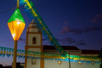 decoração junina  - igreja são joão com bandeirinhas coloridas e balão iluminado 