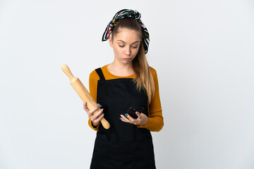 Young Lithuanian woman holding a rolling pin isolated on white background thinking and sending a message