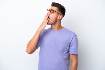 Young caucasian man isolated on white background yawning and covering wide open mouth with hand