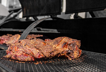 slow cooked beef brisket meat on the grill grates of a smoker barbecue
