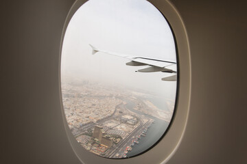 The plane-the view from the window of the porthole on the city Arab Emirates Dubai