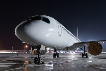 Fototapeta na wymiar Modern passenger airliner on the night airport apron