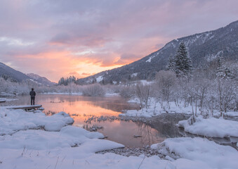 Male hiker at Zelenci springs on a winter sunrise. 