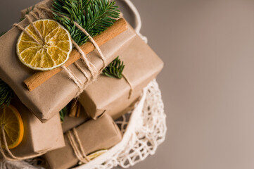 Obraz na płótnie Canvas Top view .Christmas zero waste concept. Eco friendly packaging gifts in craft paper decorated with dry oranges and branches with place for text