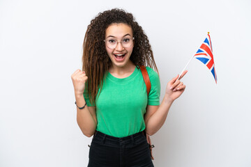 Young Arab woman holding an United Kingdom flag isolated on white background celebrating a victory...