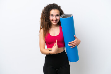 Young sport Arab woman going to yoga classes while holding a mat isolated on white background with surprise facial expression