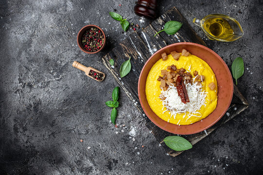 banosh with corn porridge cheese and lard on a dark background. Ukrainian cuisine. banner, menu, recipe place for text, top view