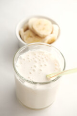 slice of banana and glass of milk on table 