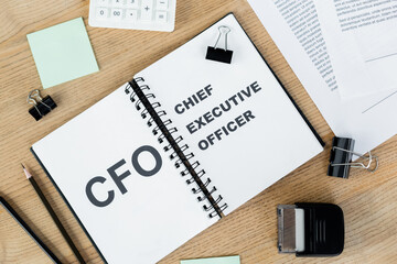 top view of notebook with cfo and chief executive officer lettering near documents and stationery.