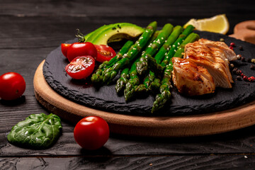 Ketogenic diet breakfast. Chicken grilled fillet with salad fresh tomatoes, asparagus and avocado. Healthy food, diet menu