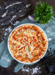 classic Italian pizza Margarita on a dark background in rustic style