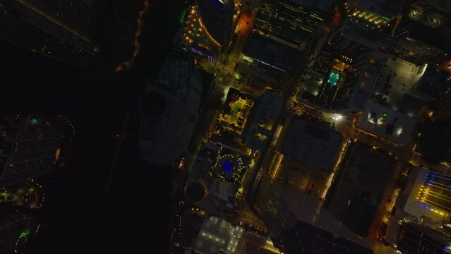 Birds eye view of downtown at night. Fly above illuminated streets and modern tall buildings. Miami, USA