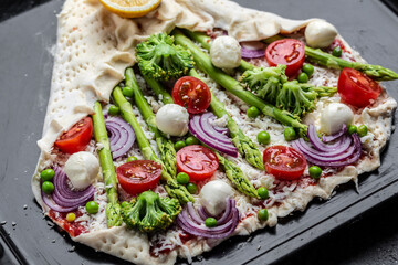 Tart with green asparagus Raw pie filled with fresh asparagus, sweet peas, mozzarella and cherry tomatoes. banner, menu recipe, top view
