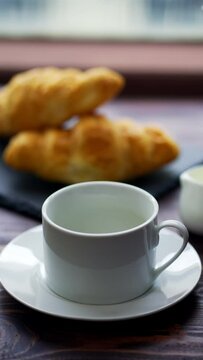 Fresh and tasty croissants and cup of hot coffee mug