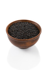 black lentil seeds in bowl on white background isolated