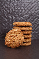 Oatmeal, fig, hazelnut, pistachio and sesame cookies on a black background. Enjoyable snack.