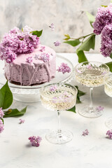 Delicious prosecco, champagne, wine with berry mousse cake bouquet of purple blooming lilacs, French cuisine, postcard, background