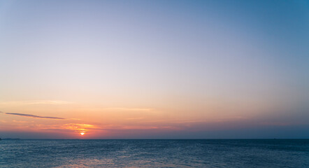 Obraz premium Dusk sky over sea in the evening with orange sunlight and sundown 