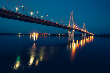 Fototapeta na wymiar night glowing bridge over the river