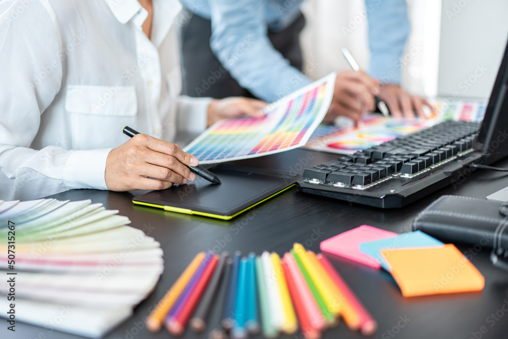Poster two creative graphic designer team working on color selection and drawing on graphic tablet, color s