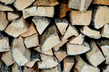 a lot of sawn firewood lies in a large pile