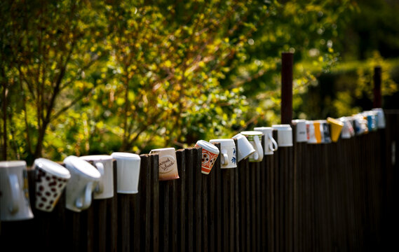 Wooden fence decorated with old ceramic mugs © Lukas