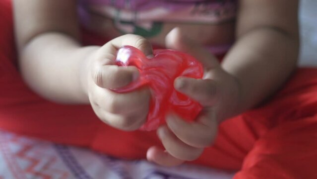 child Hand holding pink color slime 