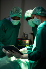The doctor is discussing the case with a tablet. Before going to surgery on the real patient