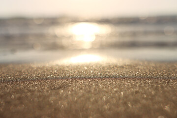 Obraz premium Sea waves and warm sunset light, calm and relaxing sandy beach