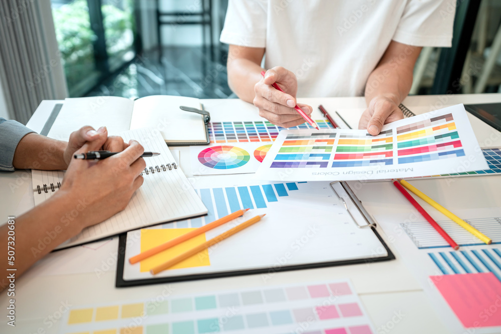Poster two creative graphic designer team working on color selection and drawing on graphic tablet, color s
