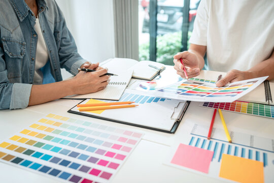 Team of creative graphic designer working on color swatch samples chart for selection coloring in inspiration to create new collection at workplace